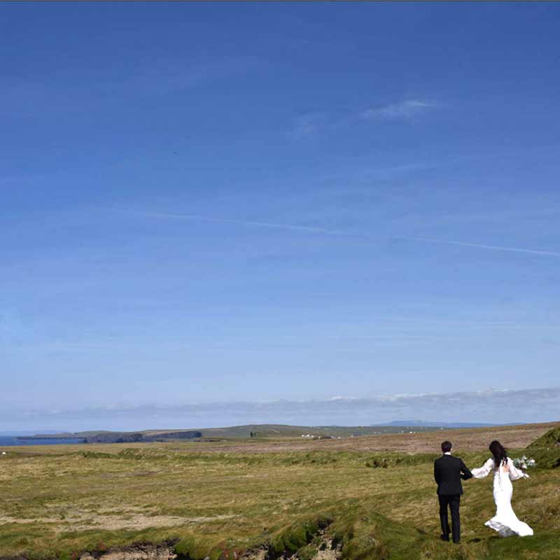 bride and groom walk towards Ballyseede castle hotel on their wedding day
